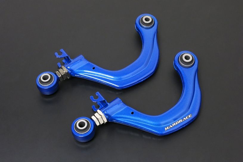 Two blue control arms with metal components on a black background